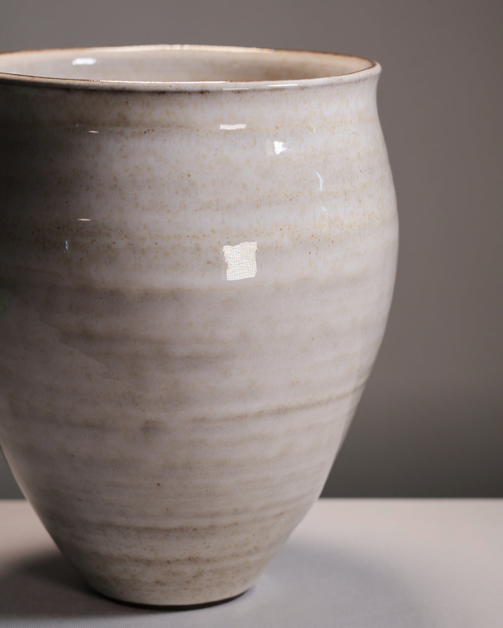 Beige ceramic vase on a gray background