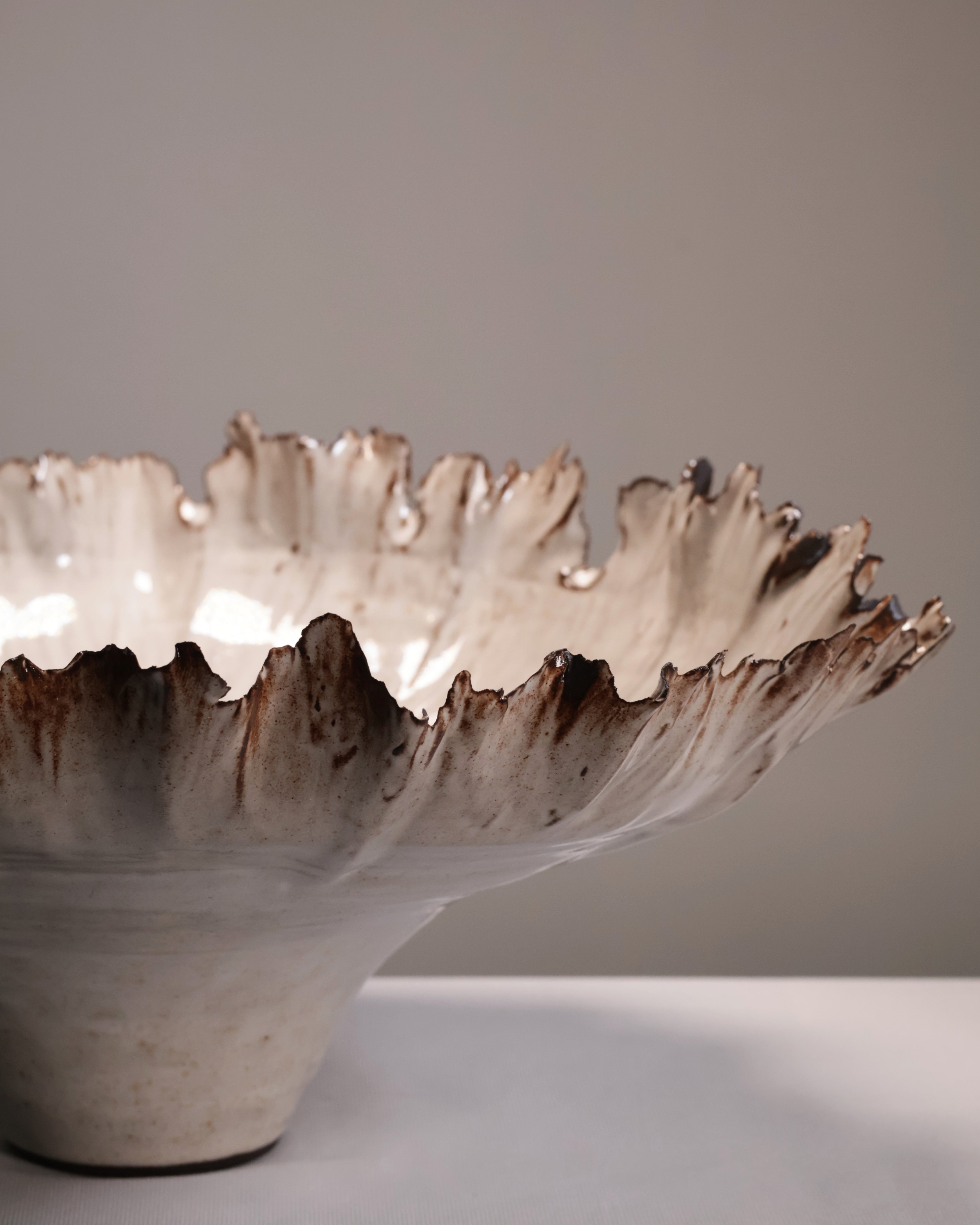 Ceramic bowl with textured edge on a neutral background