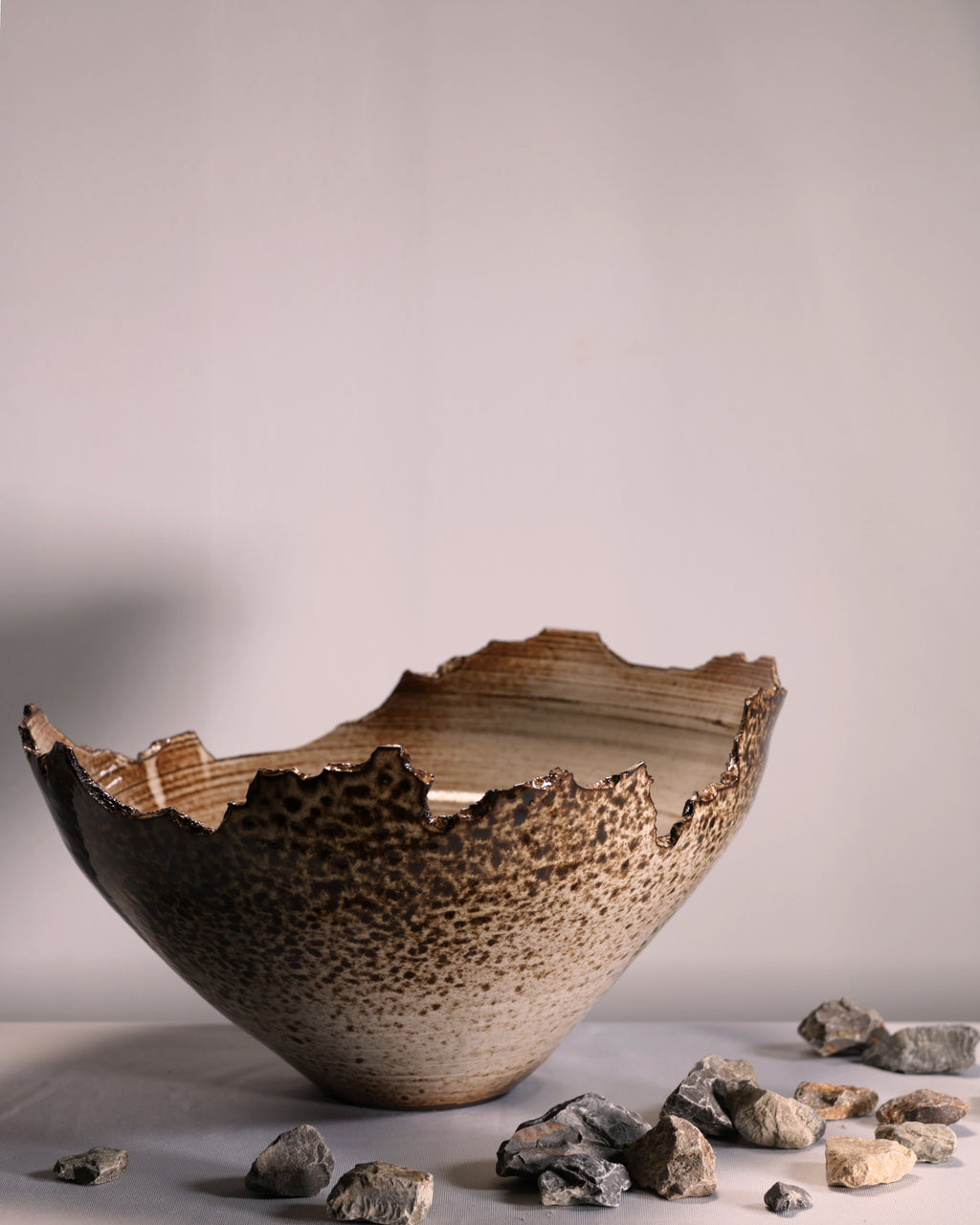 Rustic ceramic bowl with textured surface on a neutral background