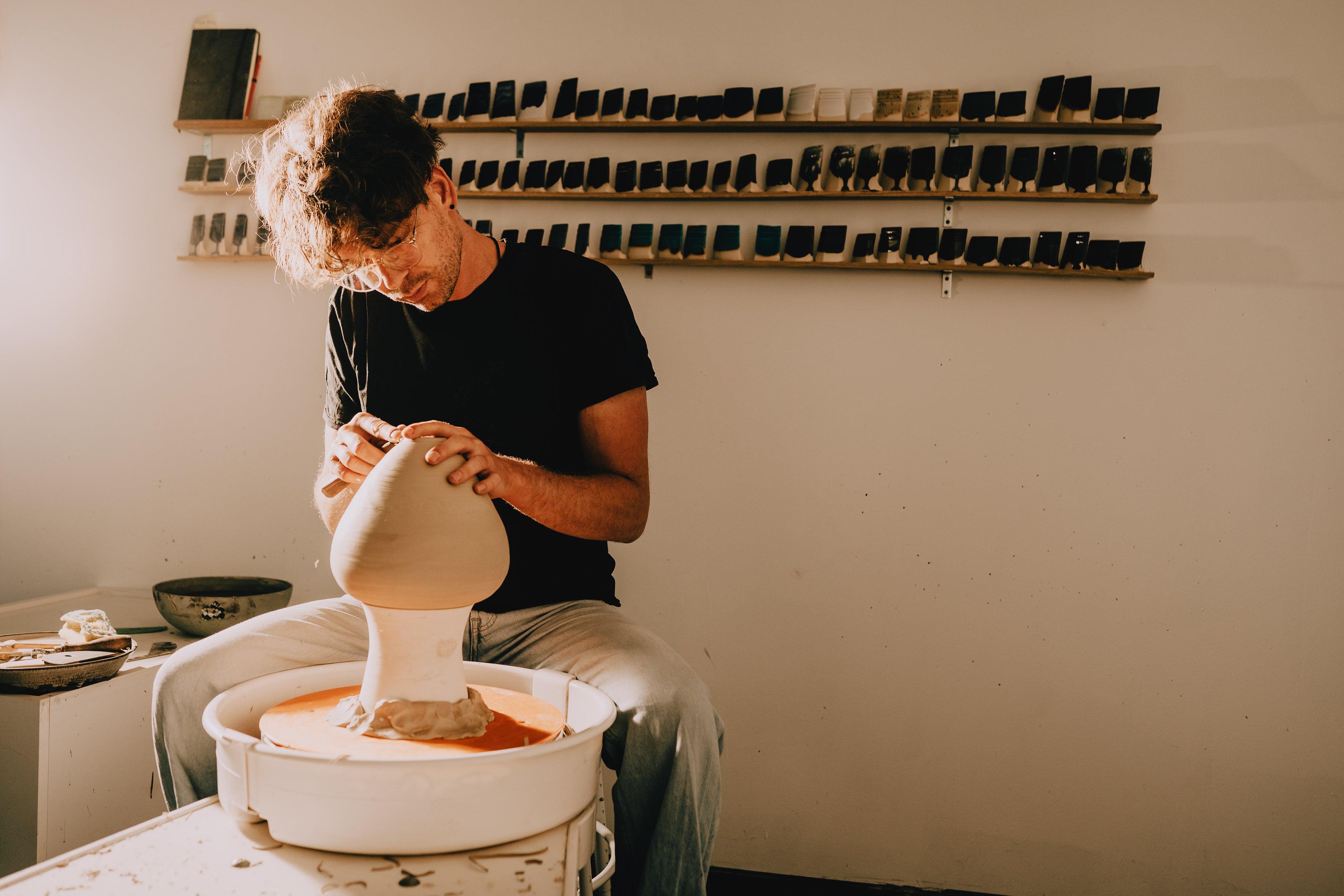Person working with clay in a pottery studio