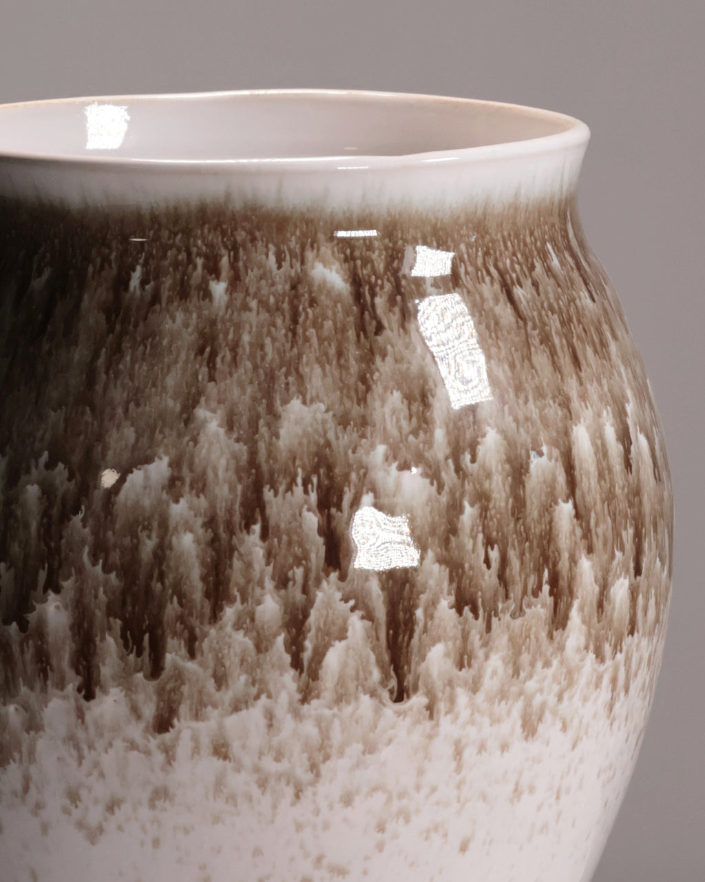 Close-up of a ceramic vase with a textured surface on a gray background